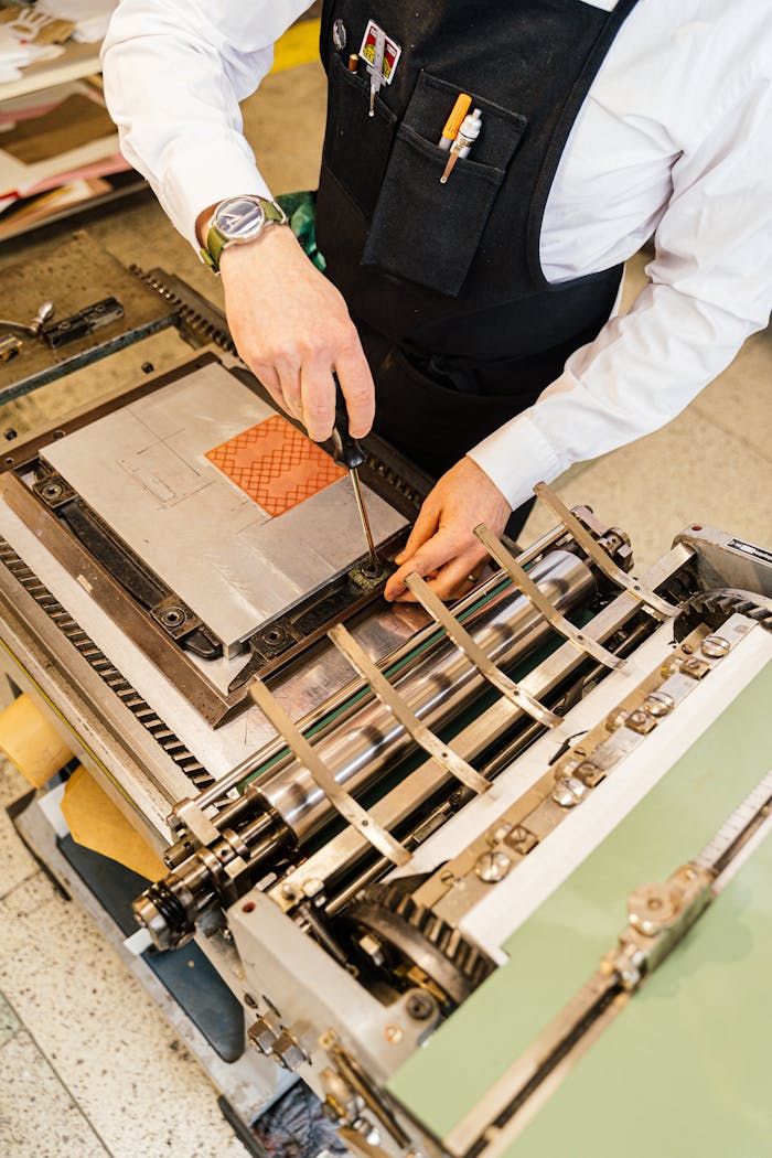An artisan in mid-action setting up a printing press, focusing on the intricacies of craftsmanship.