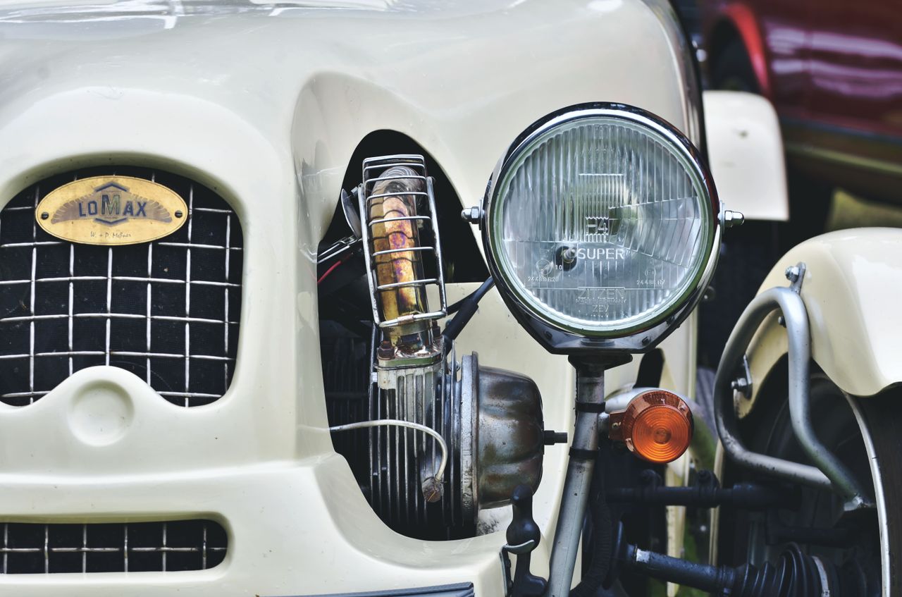 Detailed view of a vintage Lomax car headlight and grill.